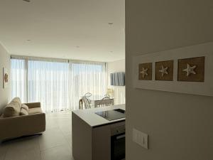 a kitchen and living room with a couch and a table at Seaside Escape in Trieste