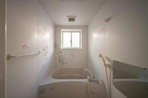 a white bathroom with a tub and a window at Oyajino Umi in Naoshima +19 photos