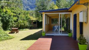 Casa con porche de madera con mesa y sillas en Les Lierrres, en Cilaos