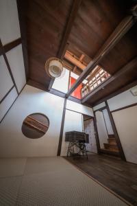 an attic room with a piano and a wooden ceiling at Oyajino Umi in Naoshima