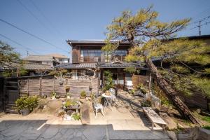 a house with a garden with a table and chairs at Oyajino Umi in Naoshima