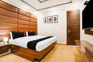 a bedroom with a large bed and a flat screen tv at Collection O Mall Road Nainital Formerly Urban Bliss in Nainital +27 photos