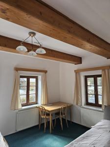 a bedroom with a table and chairs in a room at Penzion Pupík in Modrava