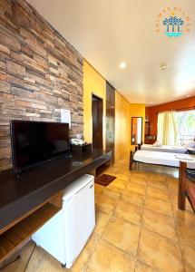 a living room with a large television and a bedroom at Palmas Del Mar Resort Bacolod in Bacolod