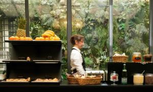 Een man loopt langs een toonbank met groenten en fruit. bij The Talent Hotel in Rome