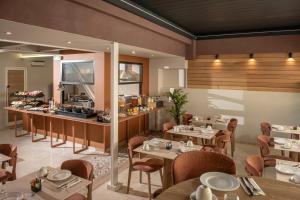 a restaurant with tables and chairs and a counter at Infinity City Boutique Hotel in Heraklio