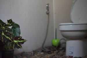 a bathroom with a toilet and a green plant at Doi Inthanon Waterfall Garden in Ban Sop Mae Klang