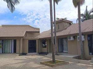 a house with palm trees in front of it at Lady Daisy Boutique Guesthouse in Rustenburg