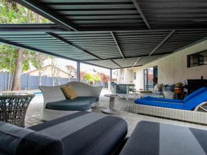 a patio with couches and chairs and a table at Lady Daisy Boutique Guesthouse in Rustenburg +16 photos