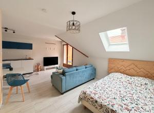 a bedroom with a bed and a blue couch at Birdie H N21 ST2 in Giez