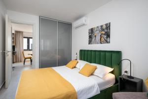a bedroom with a large bed with a green headboard at Apartment Skyline two-bedroom apartment with balcony in Cavtat