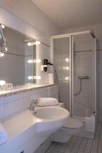 a bathroom with a sink and a shower and a toilet at Hotel Klusenhof in Lippstadt +15 photos
