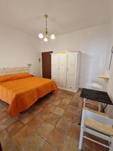 a bedroom with an orange bed and a table at B&B Nonna Sini in Castelsardo