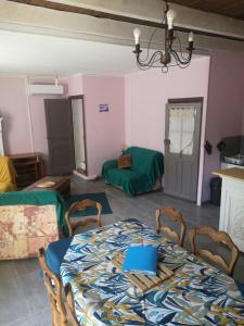 a dining room with a table and chairs and a room at Maison proche centre Les Vans in Les Vans