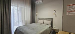 a small bedroom with a bed and a window at Hotel GLORIA in Ceadîr-Lunga