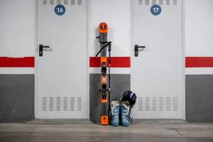 a pair of skis and a helmet sitting in front of doors at Pierre & Vacances La Merceria in El Tarter