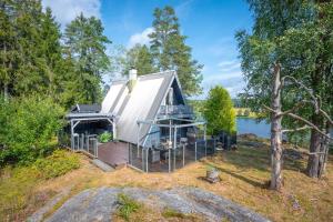 a small white house with a deck next to a body of water at Trekanthytte in Moss +5 photos