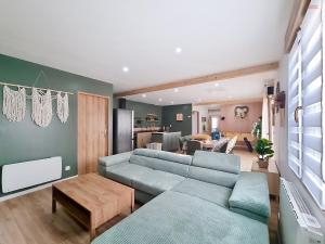 a living room with two blue couches and a table at Les Piafs du Der 2 in Joncreuil