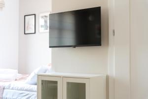 a flat screen tv on a wall in a living room at Apartament Daisy Pszczyna Centrum in Pszczyna