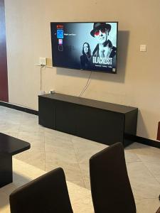 a flat screen tv on a wall in a room at Maple Lane Stays in Nakuru