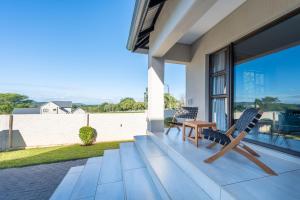 a patio with two chairs and a table on a house at Khaya Elihle Guest House in Hazyview
