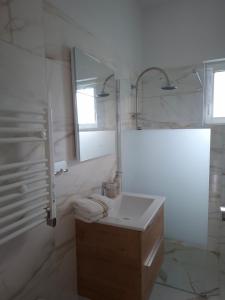 a white bathroom with a sink and a mirror at Lagonissi Summer House in Lagonissi +18 photos