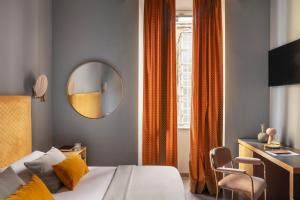 ein Schlafzimmer mit Bett, Spiegel und Schreibtisch in der Unterkunft Hotel Milani in Rom