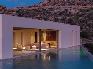 a villa with a swimming pool in front of a mountain at Crimson View Villa by Hide Out in Ios Chora +18 photos