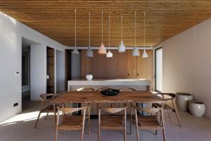 a kitchen and dining room with a wooden table and chairs at Crimson View Villa by Hide Out in Ios Chora