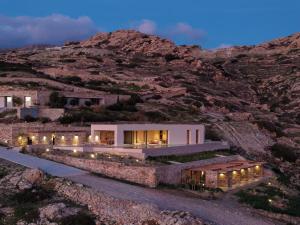 a house on the side of a mountain at night at Crimson View Villa by Hide Out in Ios Chora