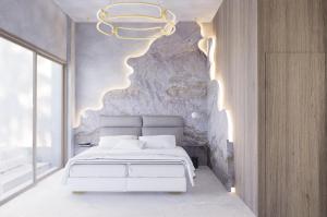 a bedroom with a white bed and a stone wall at Theretra Pefki Center in Pefki