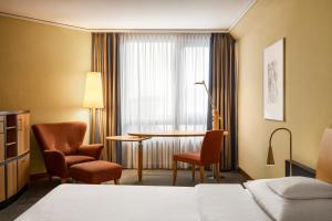 a hotel room with a bed and a table and chairs at Hotel Remarque in Osnabrück +51 photos