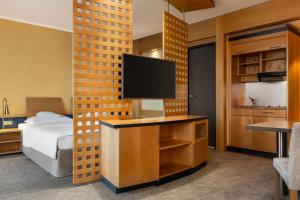 a bedroom with a bed and a television on a desk at Hotel Remarque in Osnabrück