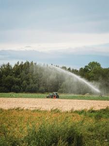 a truck spraying a field with a water hose at Idylliske Evjua ved Mjøsa in Skreia +122 photos