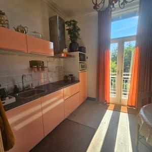 a kitchen with a sink and a large window at Appartement B&B Boskoop in Boskoop