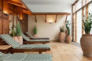 a patio with several lounge chairs and potted plants at Hotel Remarque in Osnabrück