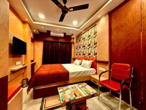 a bedroom with a bed and a ceiling fan at Bengal Guest House in Howrah