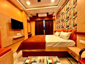 a bedroom with a bed and a flat screen tv at Bengal Guest House in Howrah +7 photos