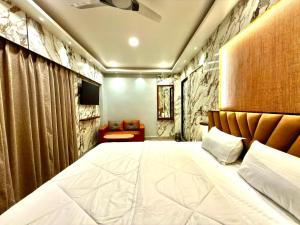a bedroom with a large white bed and a couch at Bengal Guest House in Howrah