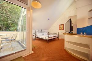 ein Wohnzimmer mit einem Bett und einer Glasschiebetür in der Unterkunft Hotel Watthalden in Ettlingen