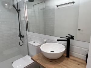 a white bathroom with a sink and a shower at Dunasol 311 in Corralejo +1 photo