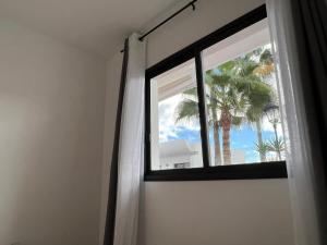 a window with a view of a palm tree at Dunasol 311 in Corralejo