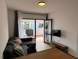 a living room with a couch and a television at Dunasol 311 in Corralejo