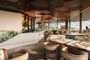 a restaurant with tables and chairs and windows at Icona's Costa Ragusa Resort - New Opening in Scoglitti