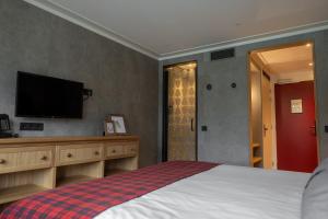 a bedroom with a bed and a flat screen tv at Badhotel Rockanje in Rockanje