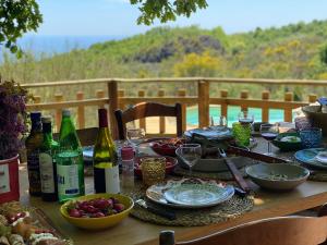a wooden table with wine bottles and plates of food at Sicily Private Pool House in Nature in Montargano