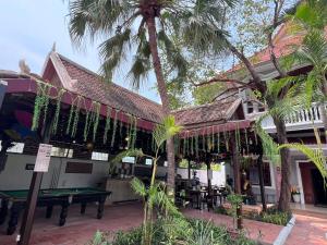 a building with a pool table and palm trees at Leaf Boutique SR in Siem Reap