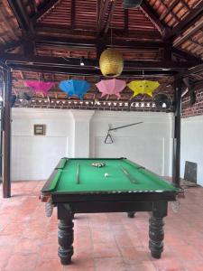 a green pool table in a room with umbrellas at Leaf Boutique SR in Siem Reap