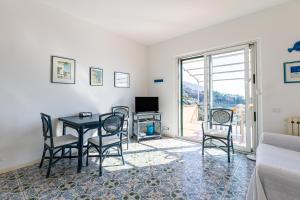 a living room with a table and chairs and a television at La Caletta Di Luce in Lerici