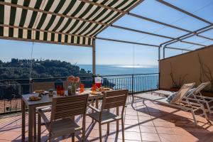 a patio with a table and chairs on a balcony at La Caletta Di Luce in Lerici
